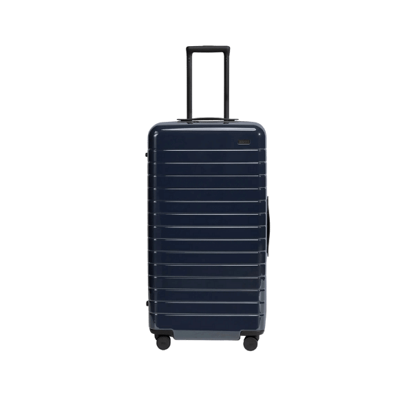 A foto mostra uma mala de viagem da marca Away na cor azul escuro.