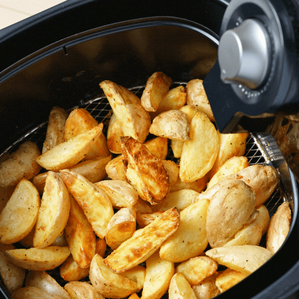A foto mostra uma cuba de uma Air Fryer cheia de batatas bem douradinhas.