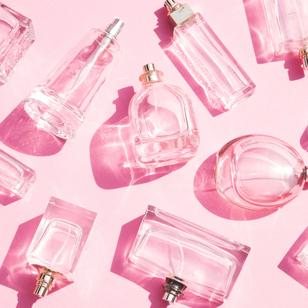 A foto do artigo onde comprar perfume original mostra vários frascos de perfumes num fundo rosa.