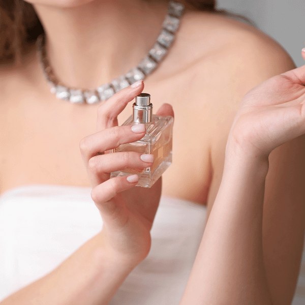 Onde comprar perfume original: a foto mostra uma mulher aplicando perfume no seu punho.
